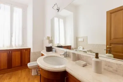 a bathroom with a sink and a large mirror at Pantheon Suites in Rome in Rome