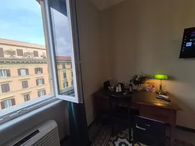 a room with a desk and a large window at HEBE Eternity Rooms in Rome