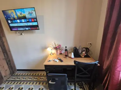 a desk in a room with a television on the wall at HEBE Eternity Rooms in Rome
