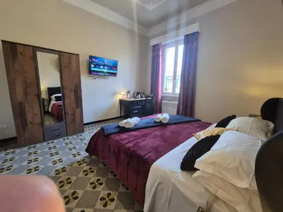 a bedroom with a large bed and a mirror at HEBE Eternity Rooms in Rome