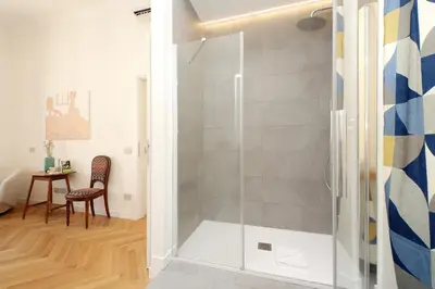 a glass shower in a bathroom with a table at Scipioni in Rome