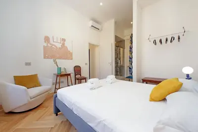 a bedroom with a white bed and a chair at Scipioni in Rome