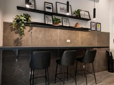 a bar with black stools in a room at Felix Rooms in Rome