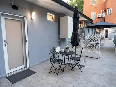 a patio with a table and chairs and an umbrella at Felix Rooms in Rome