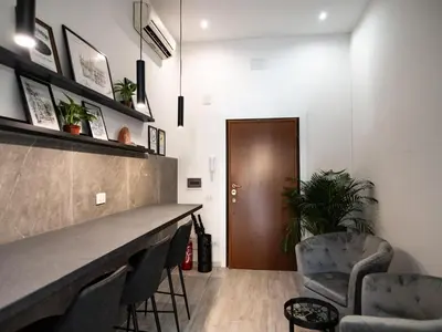 a bar in a room with two chairs and a door at Felix Rooms in Rome