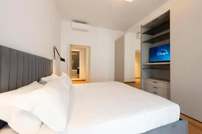 a bedroom with a white bed and a flat screen tv at Vatican Scipioni Apartment in Rome