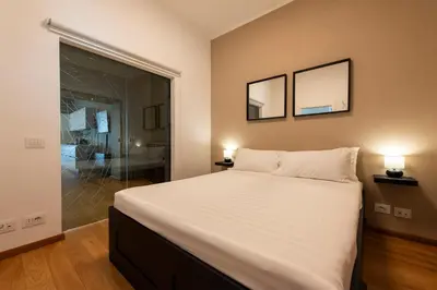 a bedroom with a large bed and a glass shower at Vatican Scipioni Apartment in Rome