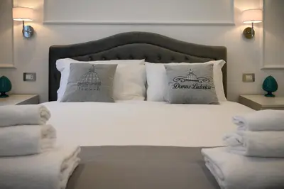 a bedroom with a white bed with pillows at Domus Ludovica in Rome