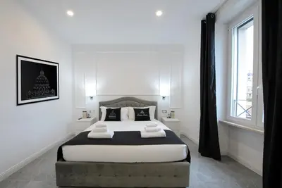 a bedroom with a large bed with two towels on it at Domus Enrico in Rome