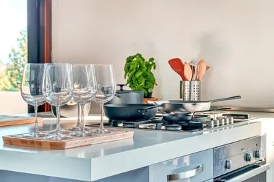 a kitchen counter with wine glasses and a stove at Skylife Art Gallery Loft - Riverfront Art Sanctuary in Rome
