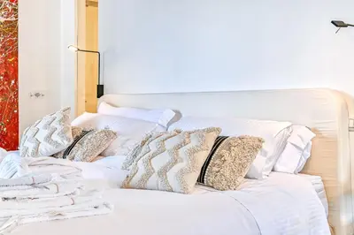 a white bed with pillows on top of it at Skylife Art Gallery Loft - Riverfront Art Sanctuary in Rome