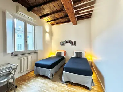 a bedroom with two beds and a window at Vetrina Roma - Stay in Luxury in Rome