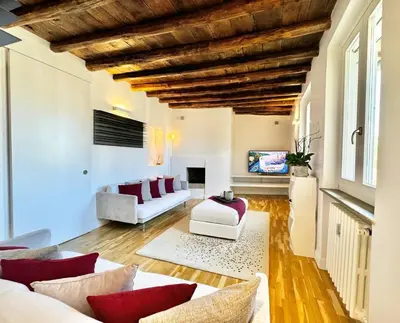 a living room with white furniture and a wooden ceiling at Vetrina Roma - Stay in Luxury in Rome