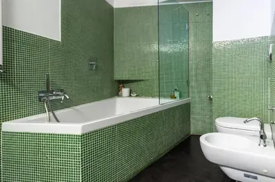 a green tiled bathroom with a tub and a toilet at Vetrina Roma - Stay in Luxury in Rome