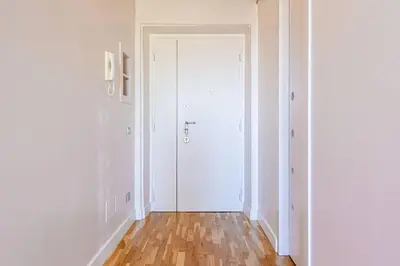 a hallway with a white door and a wooden floor at Vetrina Roma - Stay in Luxury in Rome
