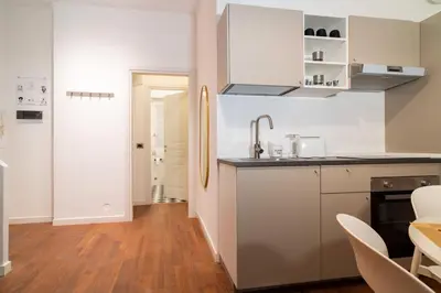 a kitchen with white cabinets and a sink at Aurea Suite Vaticano in Rome