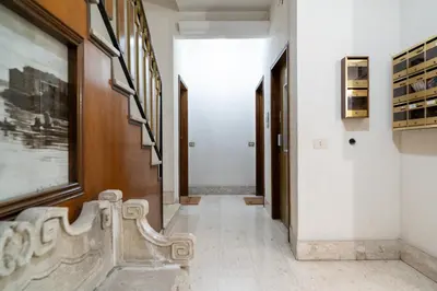 a hallway with a bench and paintings on the walls at Aurea Suite Vaticano in Rome