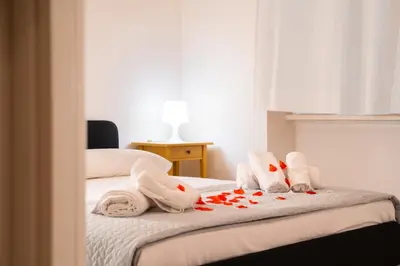 a hotel room with two beds with towels and flowers at Aurea Suite Vaticano in Rome