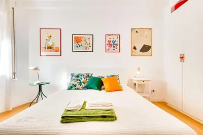 a bedroom with a large white bed with colorful pillows at Casa Ines in Rome
