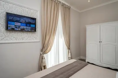 a bedroom with a bed and a tv on the wall at Charme & Chic Prestige in Rome