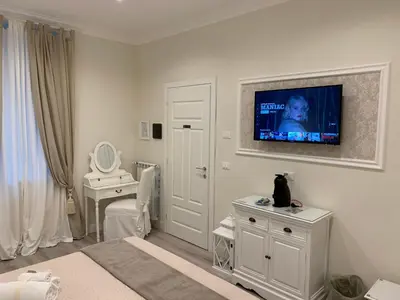 a white bedroom with a television on the wall at Charme & Chic Prestige in Rome