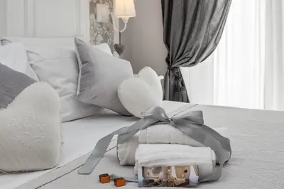 a bed with white pillows and a box of towels at Charme & Chic Prestige in Rome