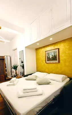a large bed in a room with a yellow wall at Olive Whisper Rome Garden and Sauna in Rome