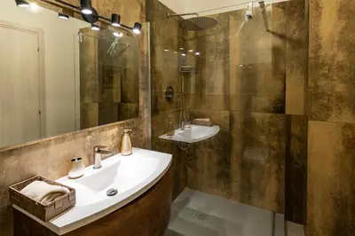 a bathroom with a sink and a shower and a mirror at Olive Whisper Rome Garden and Sauna in Rome
