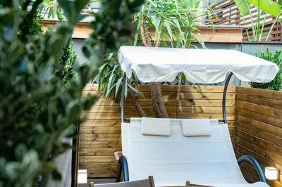 a table and chairs with a white table and umbrella at Olive Whisper Rome Garden and Sauna in Rome