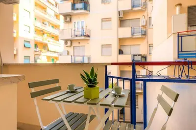 a table and chairs on a balcony with a building at Vatican Apartment - Betty Home in Rome