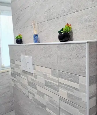 a tiled bathroom with two potted plants on a wall at Cozy apartment near metro A in Rome