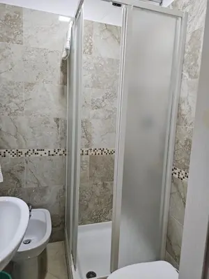 a bathroom with a shower with a toilet and a sink at Affittacamere Tiche in Rome