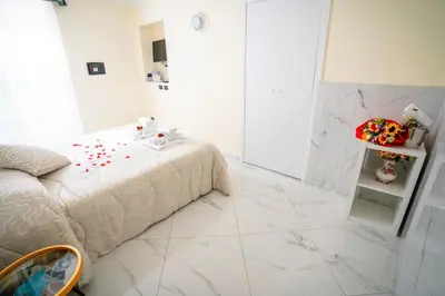 a white bedroom with a bed and a tiled floor at Affittacamere Tiche in Rome
