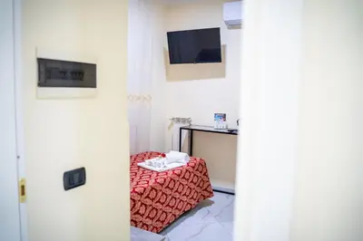 a room with a bed and a tv and a table at Affittacamere Tiche in Rome