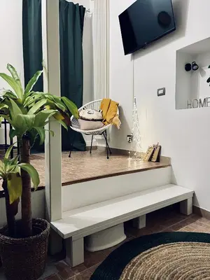 a living room with a bench and a tv at Leonardo Guest House Roma in Rome