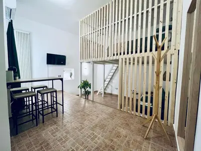 a room with a staircase and a table and chairs at Leonardo Guest House Roma in Rome