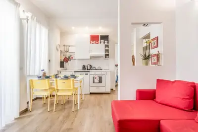 a living room with a red couch and a kitchen at True Colors Vatican Home in Rome