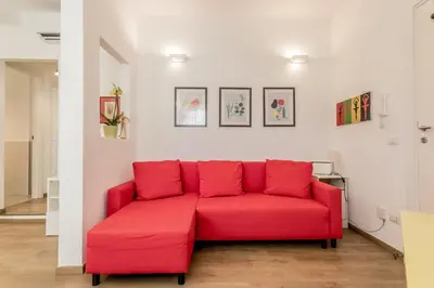 a red couch sitting in a living room at True Colors Vatican Home in Rome