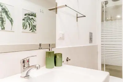 a white bathroom with a sink and a mirror at True Colors Vatican Home in Rome