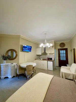 a bedroom with a bed and a table and a kitchen at Barbi's Home- Colli Albani Roma in Rome