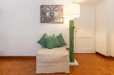 a room with a chair and a lamp and a painting at Spanish Steps Historic Apartment in Rome