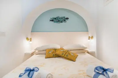 a bedroom with a bed with blue bows on it at 15 minutes to Colosseum - Loft with terrace in Rome