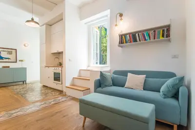 a living room with a blue couch and a table at 15 minutes to Colosseum - Loft with terrace in Rome