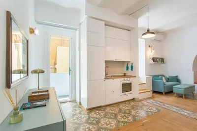 a kitchen and living room with a couch and a table at 15 minutes to Colosseum - Loft with terrace in Rome