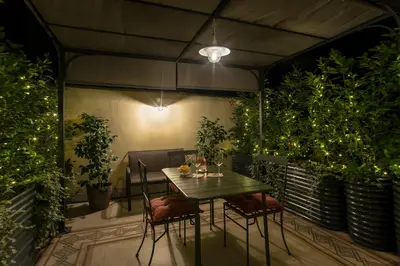 a table and chairs on a patio with plants at 15 minutes to Colosseum - Loft with terrace in Rome