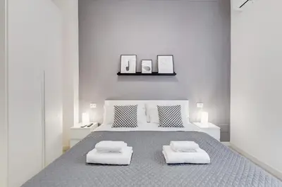 a white bedroom with a large bed with two pillows at Dimora Testaccio in Rome