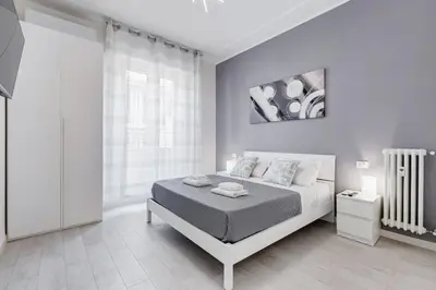 a white bedroom with a bed and a window at Dimora Testaccio in Rome