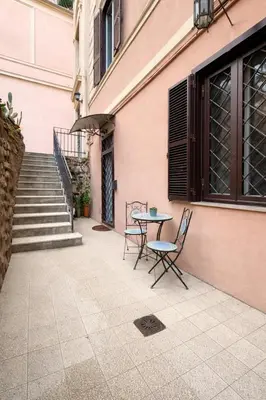 a kitchen with white cabinets and a table and chairs at Scipioni Relais in Rome