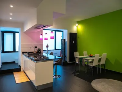 a kitchen with a table and a green wall at Conca D'oro Colors - Metro & WI-FI in Rome