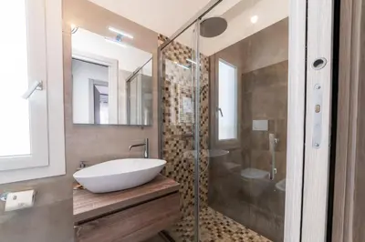 a bathroom with a sink and a glass shower at Giorgia Flat - Tiburtina Train Station - Wi-Fi in Rome